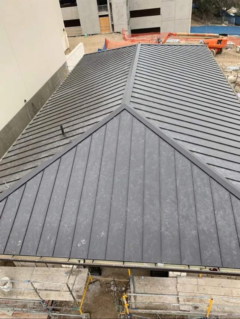 Commercial metal roof construction with crane equipment in Bryant