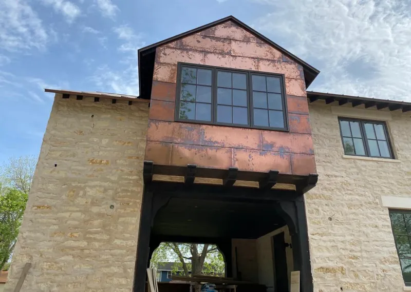 Copper metal panel facade on a stone building for Roof Repair in Bryant